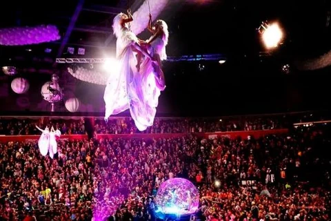 Two aerial artists performing above a crowd
